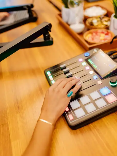 Host mixing a live podcast on the R&Oslash;DECaster console